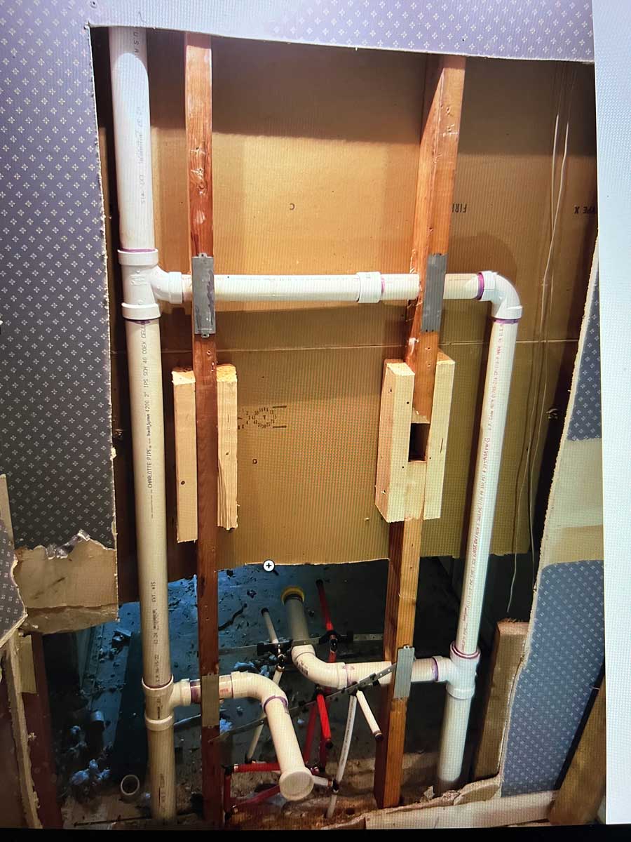 New PVC drain and vent piping installed inside an open wall